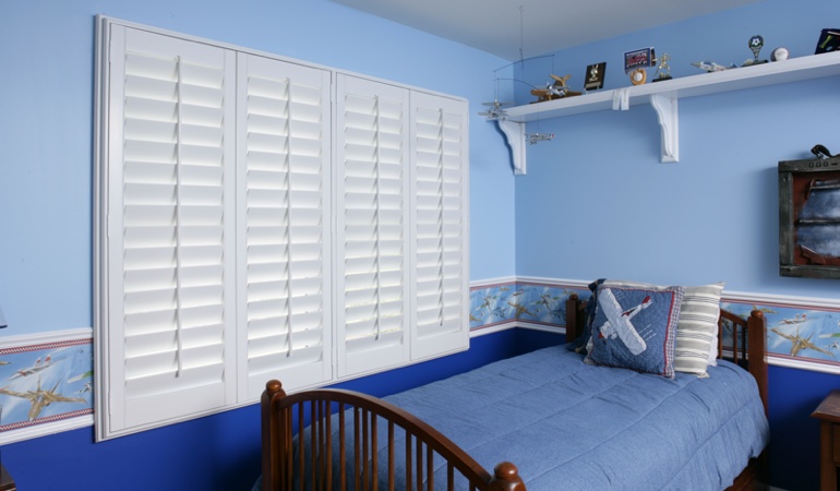 Blue kids bedroom with white plantation shutters in Fort Myers 